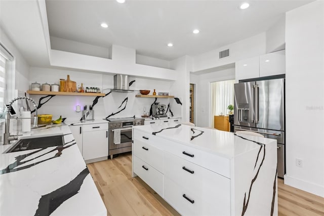 1802 Regal Mist Loop, Trinity, FL 34655 - kitchen with stainless steel appliances, open shelves, extractor fan, a kitchen island, and light wood finished floors