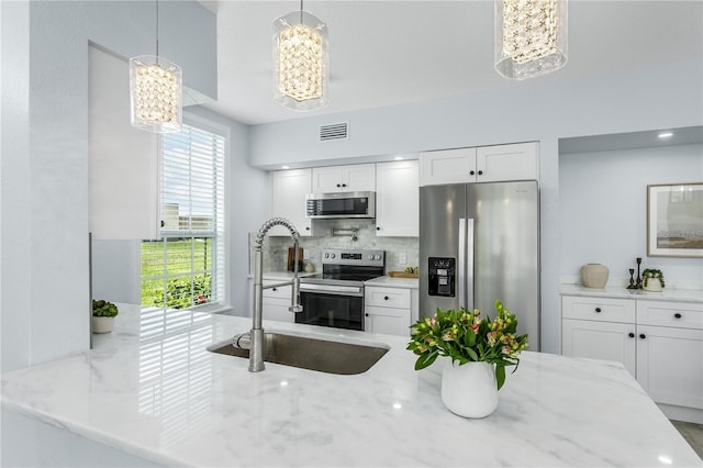 10520 White Lake Ct Unit 10520, Tampa, FL 33626 - kitchen with stainless steel appliances, a chandelier, backsplash, light stone counters, and white cabinets