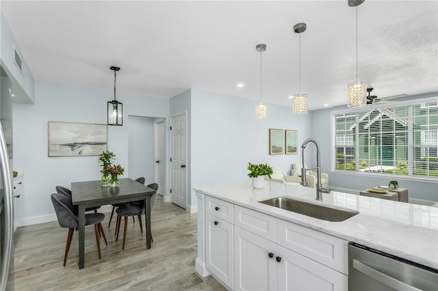 10520 White Lake Ct Unit 10520, Tampa, FL 33626 - kitchen featuring dishwasher, ceiling fan, light stone counters, light wood-type flooring, and white cabinetry