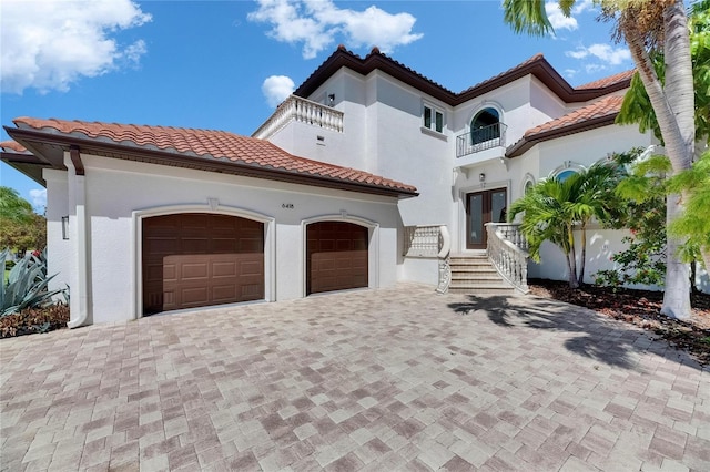 6418 Bright Bay Ct, Apollo Beach, FL 33572 - mediterranean / spanish-style house featuring a balcony, a tile roof, decorative driveway, and a garage