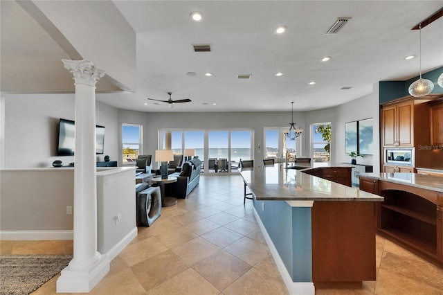 6418 Bright Bay Ct, Apollo Beach, FL 33572 - kitchen with decorative columns, recessed lighting, a large island, ceiling fan, and stainless steel microwave