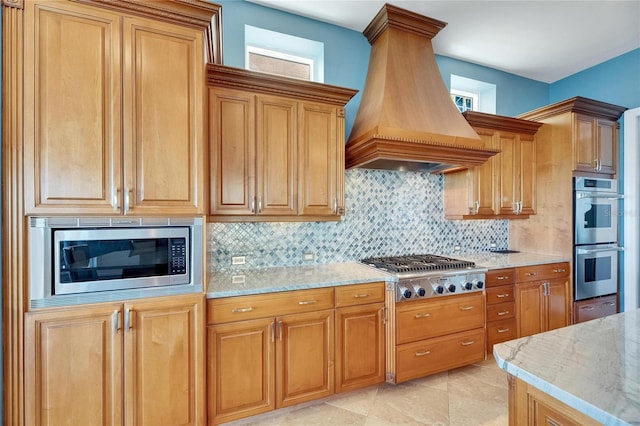 6418 Bright Bay Ct, Apollo Beach, FL 33572 - kitchen with appliances with stainless steel finishes, premium range hood, light stone counters, and decorative backsplash