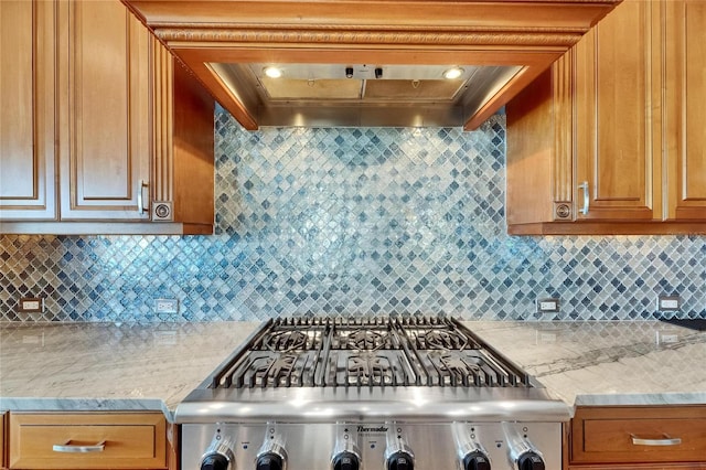 6418 Bright Bay Ct, Apollo Beach, FL 33572 - kitchen featuring range, backsplash, brown cabinets, ventilation hood, and light stone counters