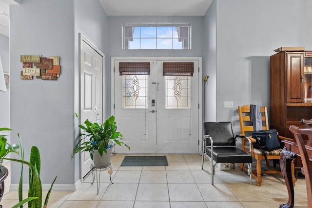 1955 Manatee Ct, Kissimmee, FL 34759 - entrance foyer with light tile patterned floors, french doors, and a towering ceiling