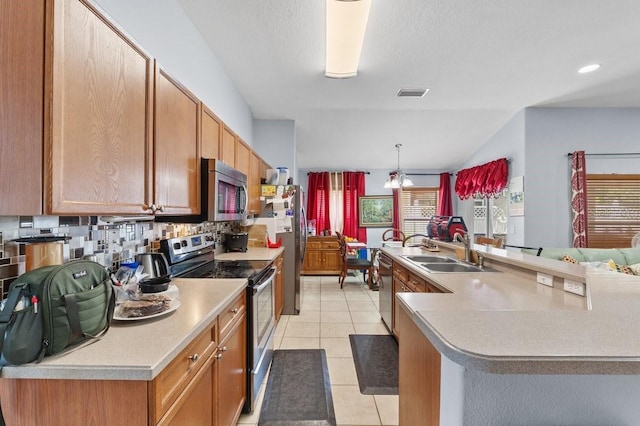 1955 Manatee Ct, Kissimmee, FL 34759 - kitchen with appliances with stainless steel finishes, light countertops, light tile patterned floors, an island with sink, and tasteful backsplash