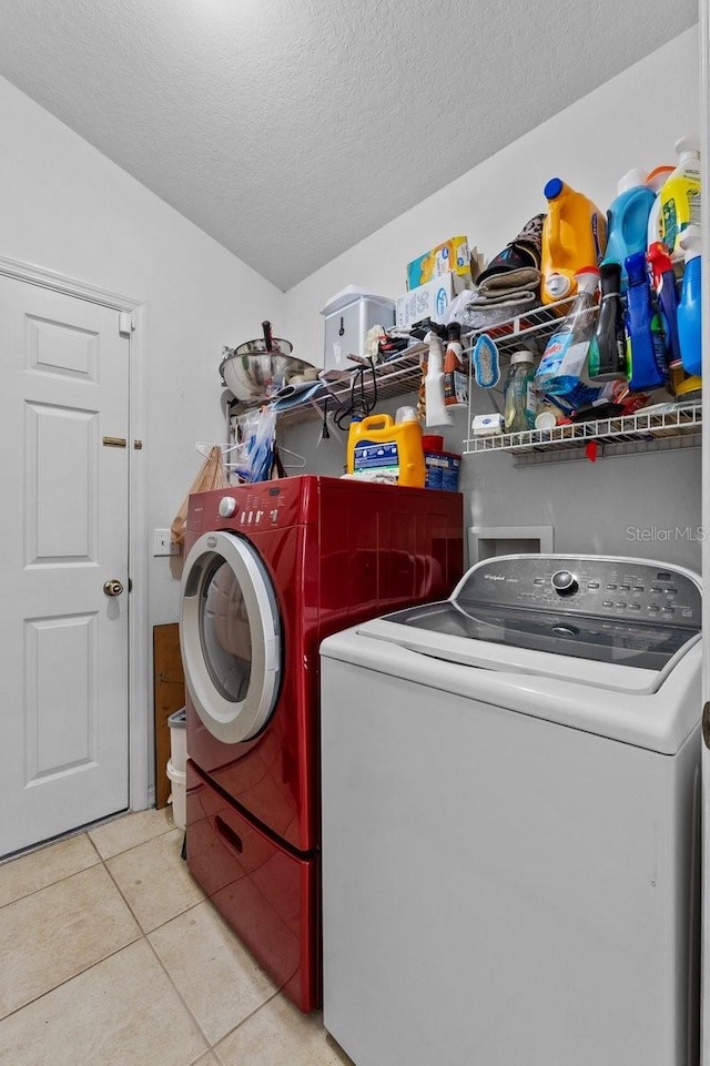 1955 Manatee Ct, Kissimmee, FL 34759 - laundry area featuring washing machine and clothes dryer, tile patterned floors, and a textured ceiling