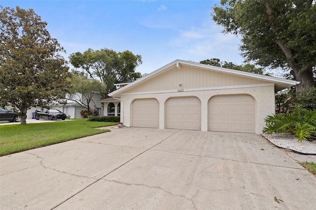 10053 W Bay St, Seminole, FL 33776 - view of front of home featuring driveway, an attached garage, and a front lawn
