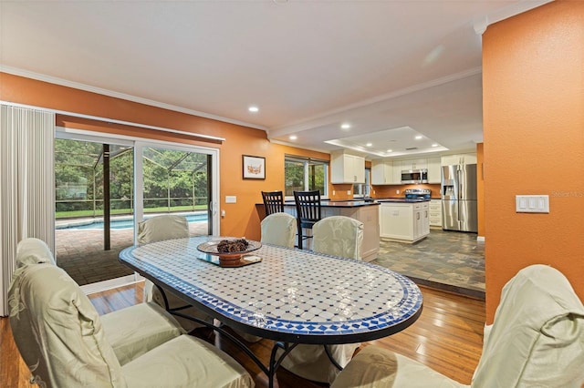 10053 W Bay St, Seminole, FL 33776 - dining space featuring ornamental molding, wood finished floors, recessed lighting, and a sunroom