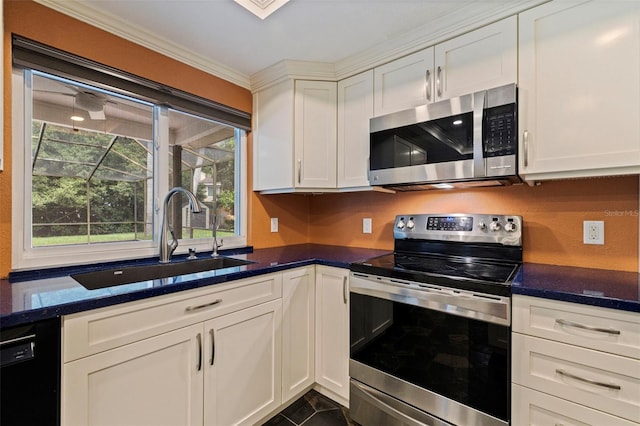10053 W Bay St, Seminole, FL 33776 - kitchen with appliances with stainless steel finishes, white cabinetry, crown molding, dark stone countertops, and dark tile patterned flooring
