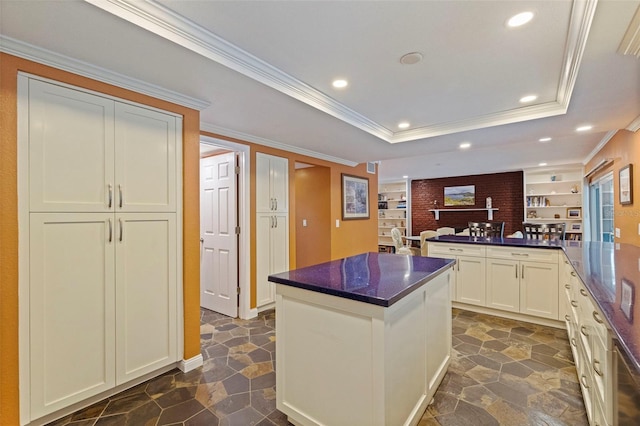 10053 W Bay St, Seminole, FL 33776 - kitchen with recessed lighting, crown molding, a center island, a tray ceiling, and dark stone countertops