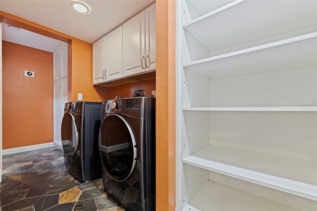 10053 W Bay St, Seminole, FL 33776 - laundry area featuring cabinet space, dark stone finish flooring, and separate washer and dryer