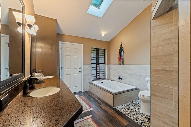 10053 W Bay St, Seminole, FL 33776 - full bathroom with a skylight, tile walls, a whirlpool tub, double vanity, and lofted ceiling