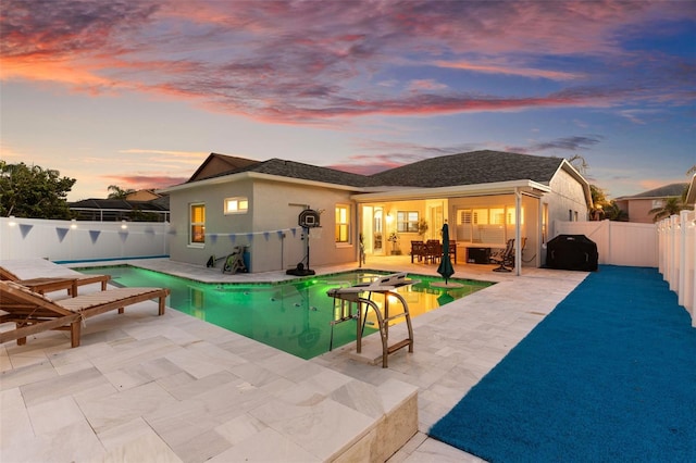 1631 Shady Oaks Dr, Oldsmar, FL 34677 - back of property at dusk featuring a fenced backyard, stucco siding, and a patio area