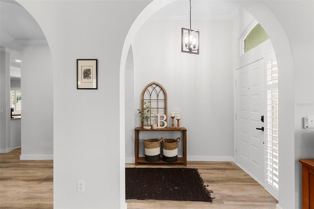 1631 Shady Oaks Dr, Oldsmar, FL 34677 - entryway featuring wood finished floors, ornamental molding, arched walkways, and a chandelier