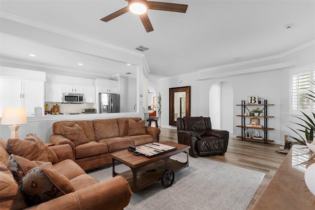 1631 Shady Oaks Dr, Oldsmar, FL 34677 - living room with arched walkways, crown molding, a ceiling fan, light wood-style flooring, and recessed lighting