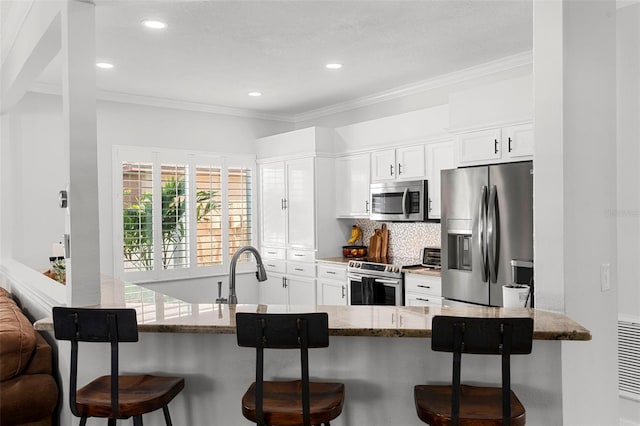 1631 Shady Oaks Dr, Oldsmar, FL 34677 - kitchen featuring stainless steel appliances, a kitchen breakfast bar, light stone counters, ornamental molding, and decorative backsplash