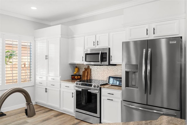 1631 Shady Oaks Dr, Oldsmar, FL 34677 - kitchen with stainless steel appliances, light wood finished floors, white cabinetry, crown molding, and backsplash