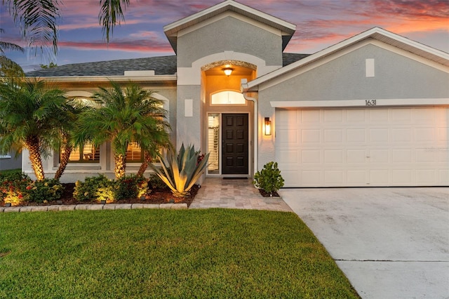 1631 Shady Oaks Dr, Oldsmar, FL 34677 - view of front of house with an attached garage, stucco siding, concrete driveway, a yard, and a shingled roof