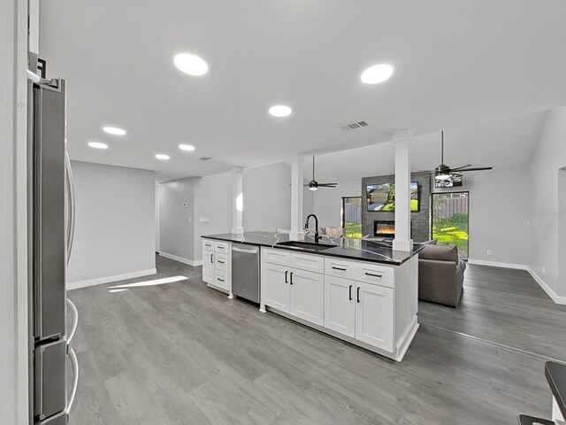 852 Village Way, Palm Harbor, FL 34683 - kitchen with open floor plan, appliances with stainless steel finishes, a ceiling fan, dark countertops, and recessed lighting
