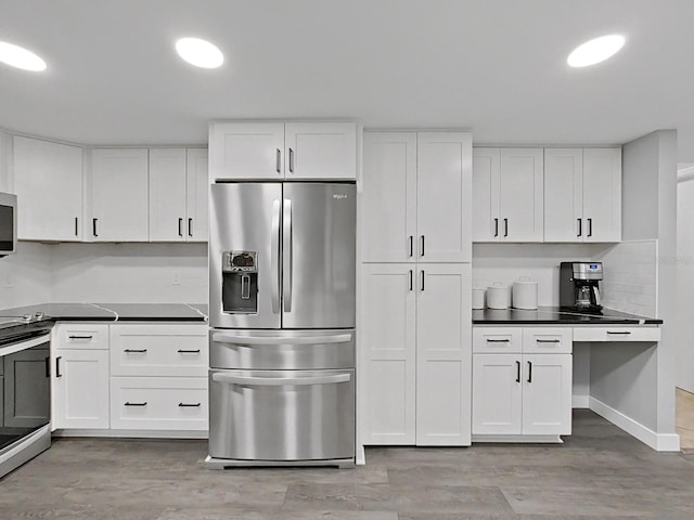 852 Village Way, Palm Harbor, FL 34683 - kitchen with appliances with stainless steel finishes, white cabinetry, dark countertops, and recessed lighting