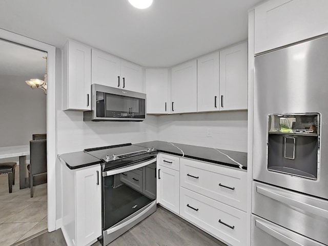 852 Village Way, Palm Harbor, FL 34683 - kitchen with appliances with stainless steel finishes, dark countertops, and white cabinets