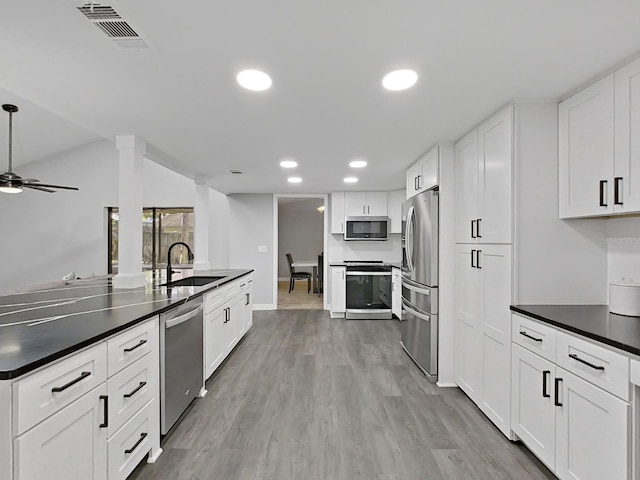852 Village Way, Palm Harbor, FL 34683 - kitchen with stainless steel appliances, dark countertops, recessed lighting, and white cabinetry