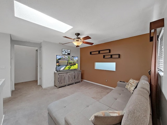 852 Village Way, Palm Harbor, FL 34683 - living room featuring a skylight, light colored carpet, a ceiling fan, and plenty of natural light