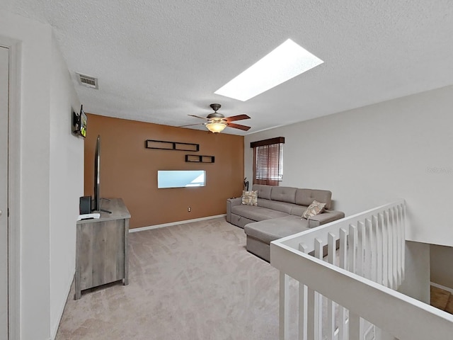 852 Village Way, Palm Harbor, FL 34683 - living room with a skylight, light carpet, a ceiling fan, and a textured ceiling