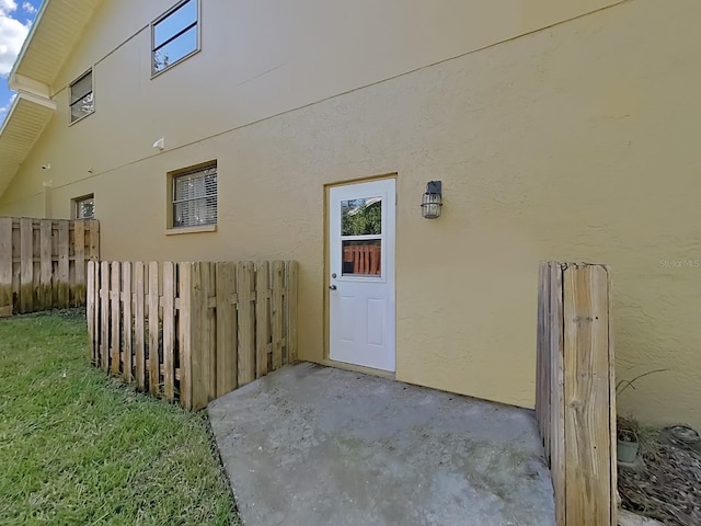 852 Village Way, Palm Harbor, FL 34683 - view of exterior entry featuring stucco siding and a patio