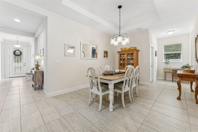 1237 Windy Bay Shl, Tarpon Springs, FL 34689 - dining space with light tile patterned flooring, a tray ceiling, and a chandelier