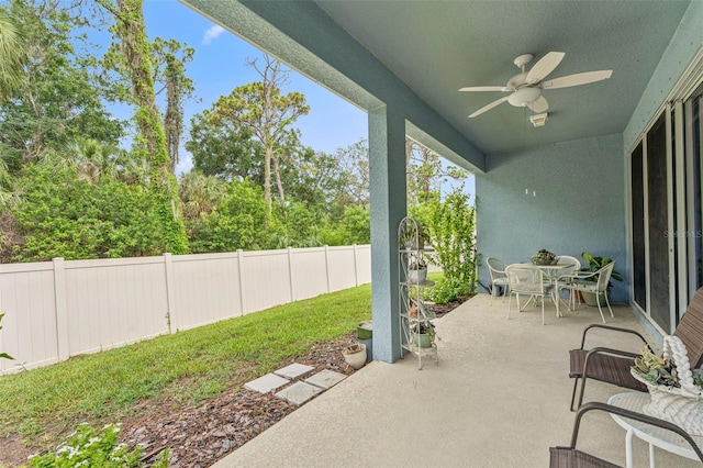 1237 Windy Bay Shl, Tarpon Springs, FL 34689 - fenced backyard with a ceiling fan, a patio area, and outdoor dining space