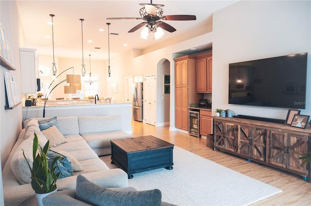 6804 Pleasant Oaks Pl, Riverview, FL 33578 - living area with wine cooler, ceiling fan, light wood finished floors, and arched walkways