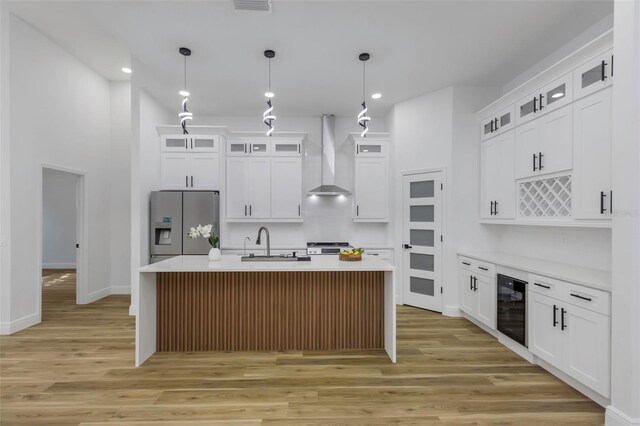 1213 E Lemon St, Tarpon Springs, FL 34689 - kitchen featuring stainless steel fridge, wall chimney exhaust hood, wine cooler, light wood-type flooring, and recessed lighting