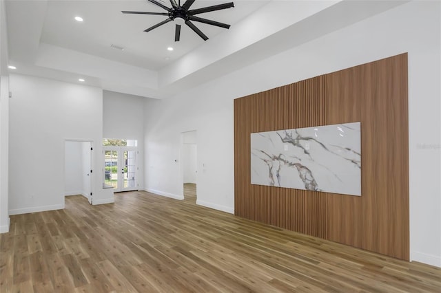 1213 E Lemon St, Tarpon Springs, FL 34689 - unfurnished living room with wood finished floors, a ceiling fan, a high ceiling, recessed lighting, and a raised ceiling