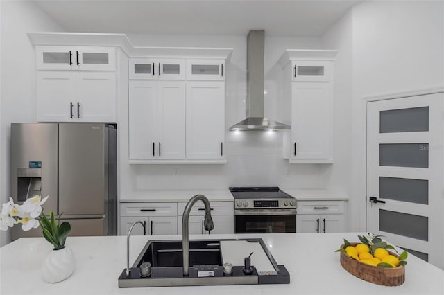 1213 E Lemon St, Tarpon Springs, FL 34689 - kitchen featuring appliances with stainless steel finishes, wall chimney range hood, white cabinetry, and light countertops