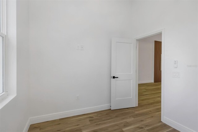1213 E Lemon St, Tarpon Springs, FL 34689 - empty room with baseboards and wood finished floors
