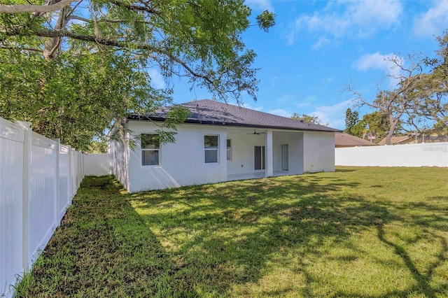 1213 E Lemon St, Tarpon Springs, FL 34689 - rear view of house featuring stucco siding, a ceiling fan, a fenced backyard, and a shingled roof