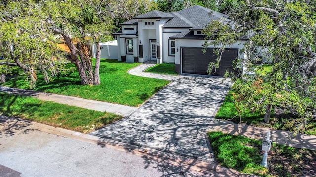 1213 E Lemon St, Tarpon Springs, FL 34689 - view of front facade with stucco siding, a front yard, a garage, driveway, and a shingled roof
