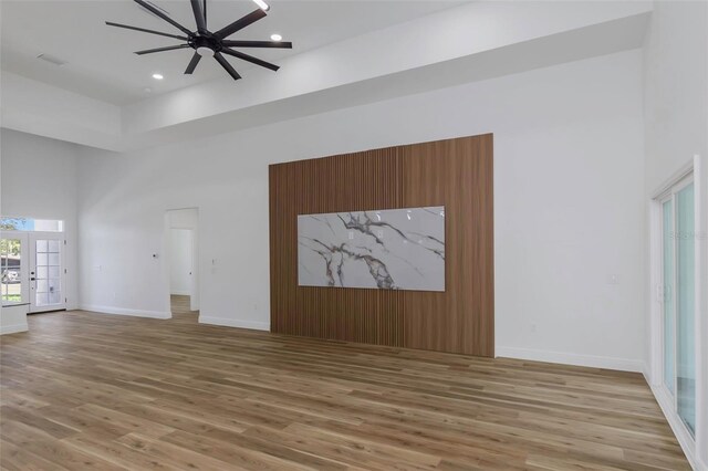 1213 E Lemon St, Tarpon Springs, FL 34689 - unfurnished living room featuring light wood-type flooring, a high ceiling, ceiling fan, recessed lighting, and french doors