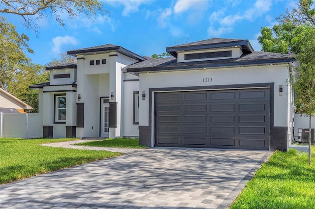 1213 E Lemon St, Tarpon Springs, FL 34689 - view of front of home with stucco siding, an attached garage, decorative driveway, and roof with shingles