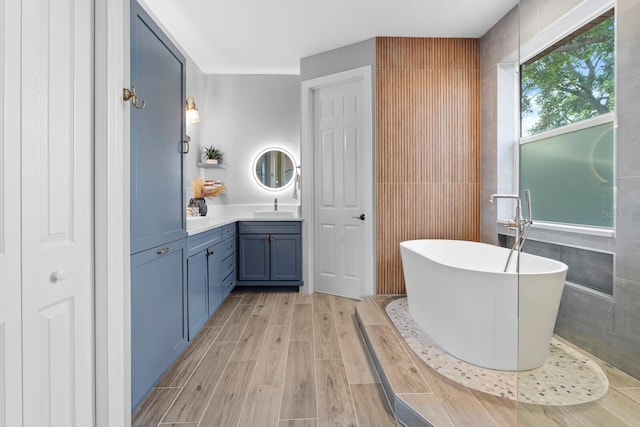3307 W Knights Ave, Tampa, FL 33611 - bathroom featuring vanity, a soaking tub, tile walls, and wood finished floors