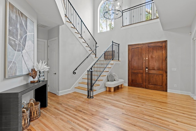 3307 W Knights Ave, Tampa, FL 33611 - foyer featuring stairway, wood finished floors, a chandelier, a high ceiling, and healthy amount of natural light