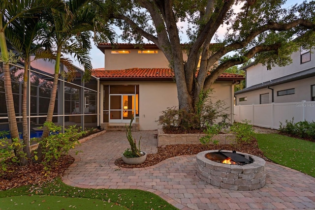 3307 W Knights Ave, Tampa, FL 33611 - back of house with a tiled roof, an outdoor fire pit, a patio area, and stucco siding