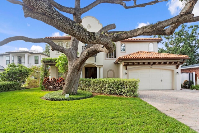 3307 W Knights Ave, Tampa, FL 33611 - mediterranean / spanish home featuring stucco siding, decorative driveway, an attached garage, and a tiled roof