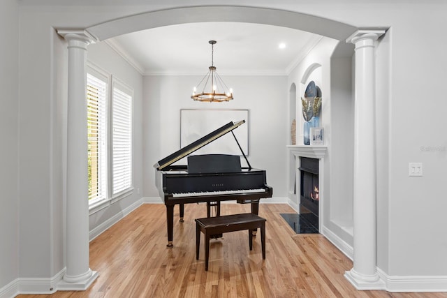 3307 W Knights Ave, Tampa, FL 33611 - sitting room featuring light wood finished floors, healthy amount of natural light, crown molding, a fireplace with flush hearth, and ornate columns