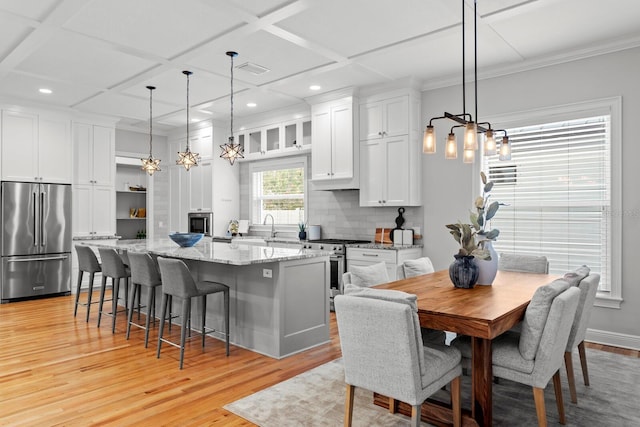 3307 W Knights Ave, Tampa, FL 33611 - kitchen featuring stainless steel appliances, light wood finished floors, white cabinetry, a breakfast bar, and a chandelier