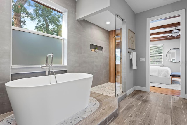 3307 W Knights Ave, Tampa, FL 33611 - ensuite bathroom with a freestanding tub, beam ceiling, wood finished floors, a tile shower, and tile walls