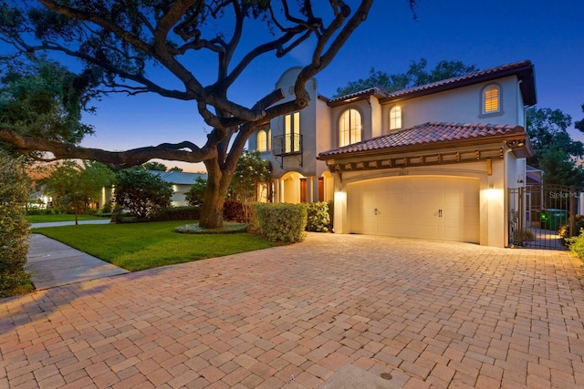 3307 W Knights Ave, Tampa, FL 33611 - mediterranean / spanish home featuring stucco siding, decorative driveway, a tiled roof, a garage, and a gate