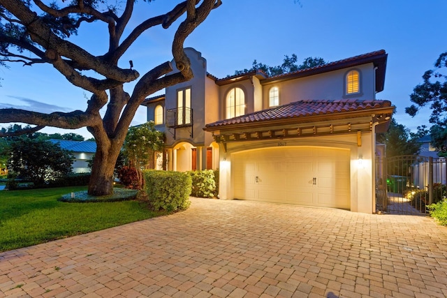 3307 W Knights Ave, Tampa, FL 33611 - mediterranean / spanish house featuring decorative driveway, stucco siding, a tiled roof, and a garage