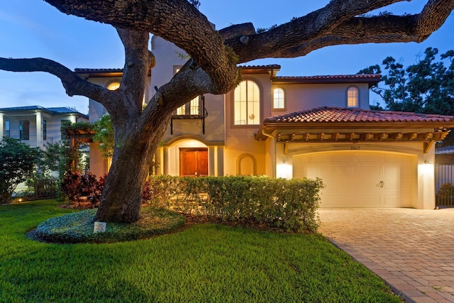 3307 W Knights Ave, Tampa, FL 33611 - mediterranean / spanish house with stucco siding, decorative driveway, a front yard, a tiled roof, and an attached garage